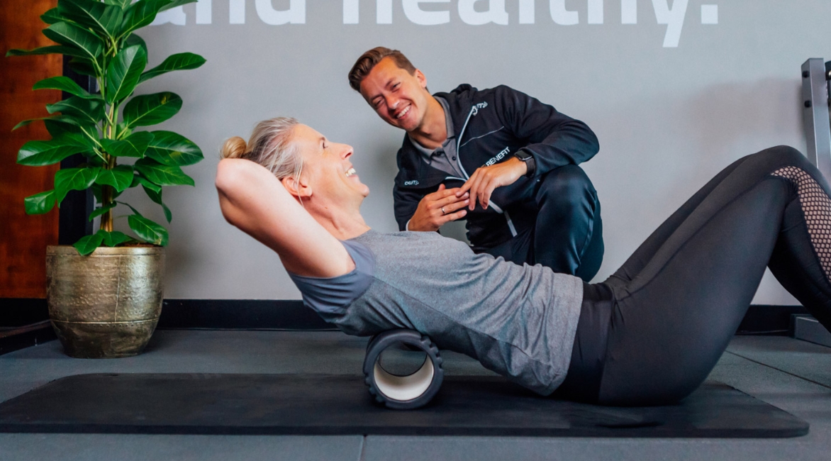 EREPS-5 personal trainer coaching mid-60s client in private studio with green branding